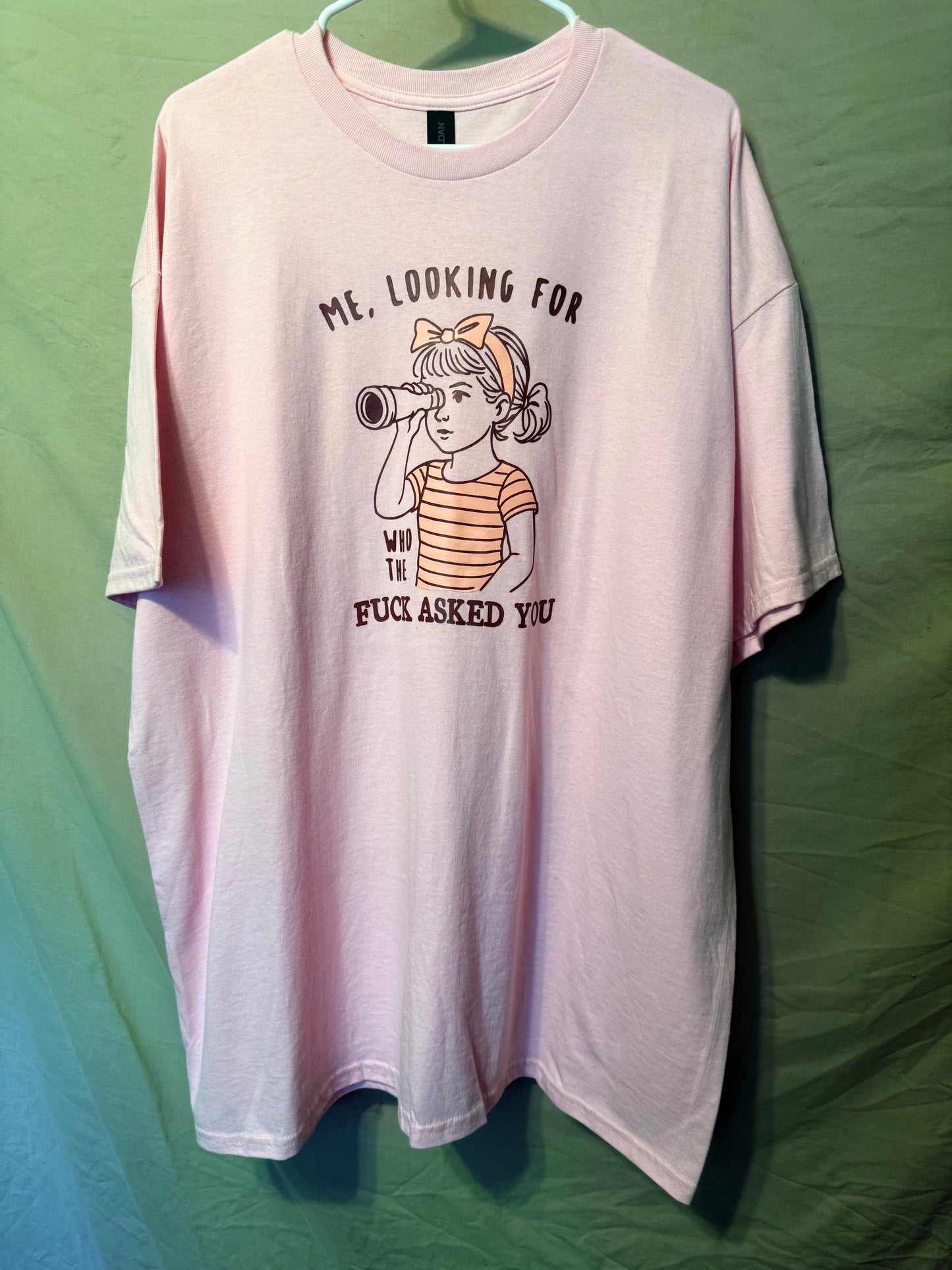 Pink t-shirt with graphic design and text on a green background